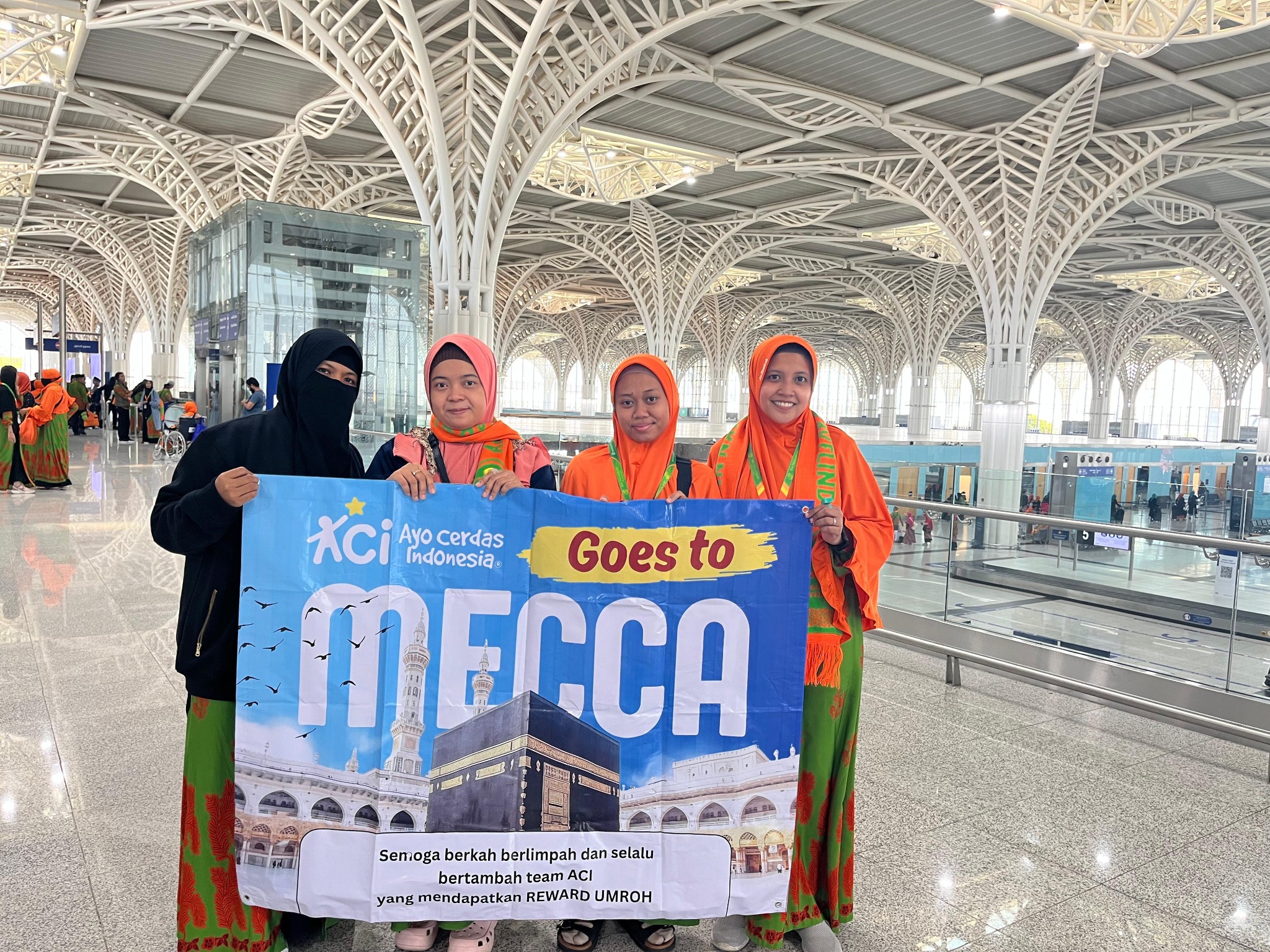 Anggota tim ACI membawa banner Reward Umroh di area keberangkatan bandara