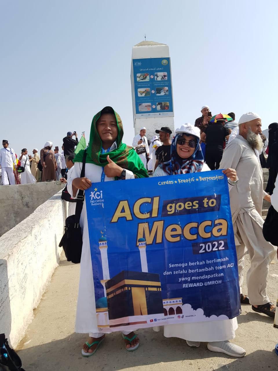 Anggota tim ACI membawa banner Reward Umroh dalam perjalanan ibadah